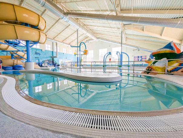 Indoor swimming pool with water slides and play area at Meeker Rec Center.
