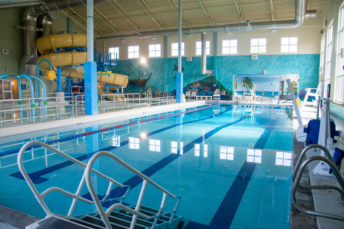 Indoor swimming pool with lap lanes and a yellow water slide.