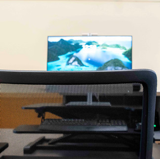 An image of a chair with a blurry computer screen in the background.