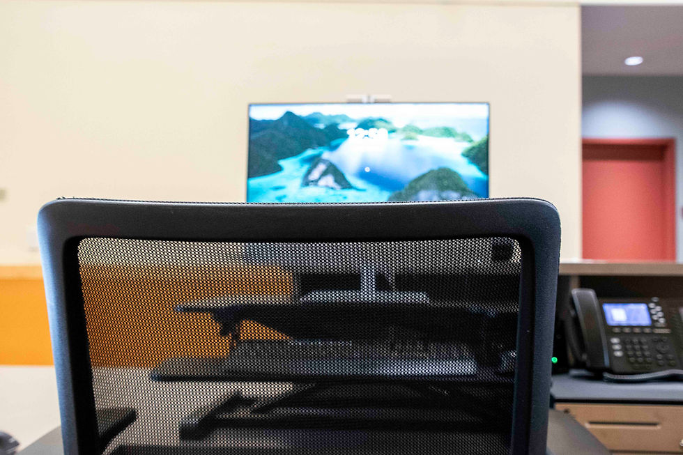 An image of a chair with a blurry computer screen in the background.