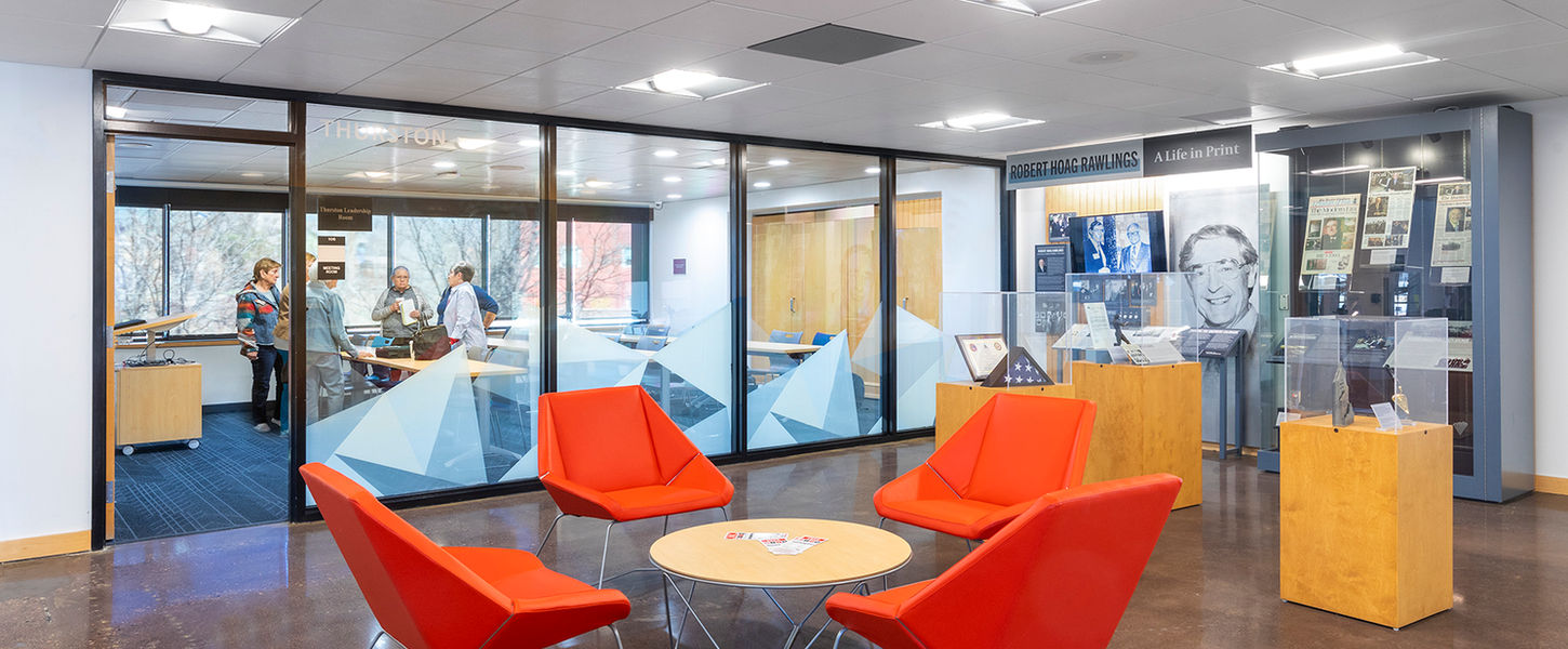 The Rawlings Library meeting space combines history and modern functionality, featuring an exhibit on Robert Hoag Rawlings and a collaborative seating area. This space fosters learning, discussion, and community engagement in a visually rich setting.