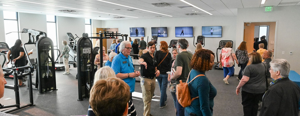 A guided tour of the fitness area introduces visitors to the gym’s equipment, including treadmills, strength machines, and free weights.