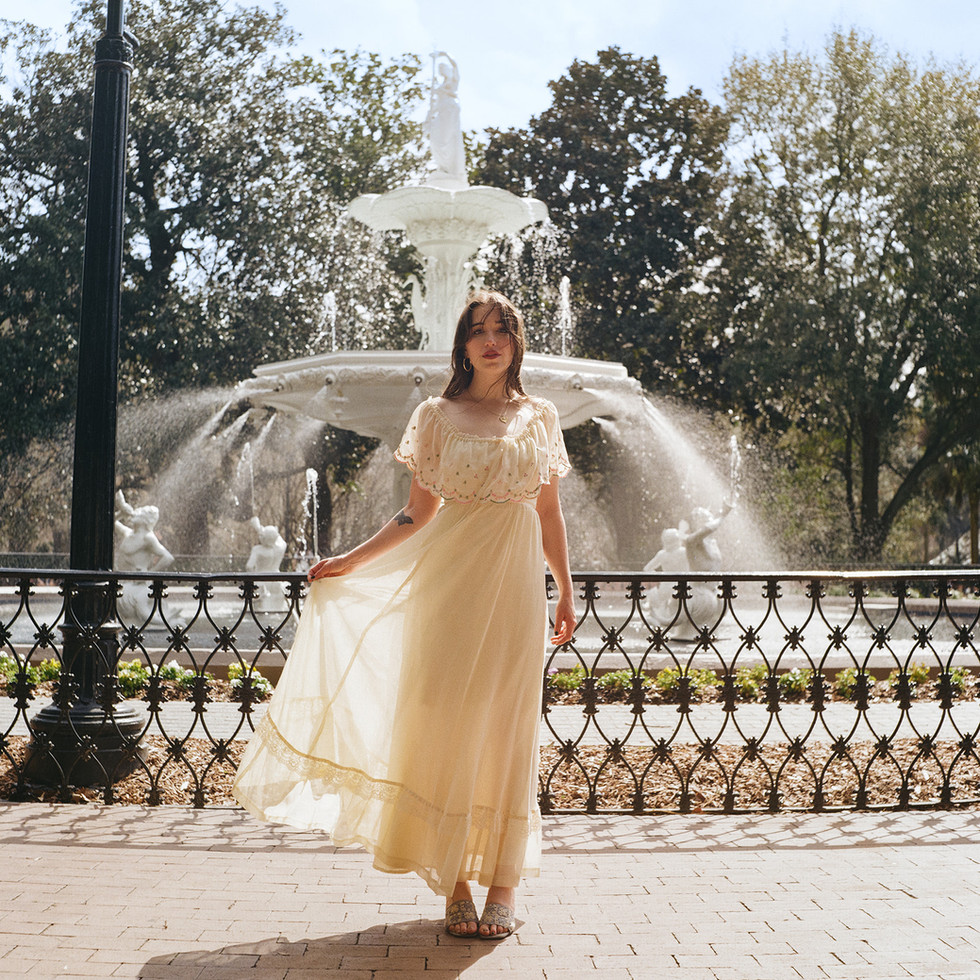 Wide shot of bride centered at Forsyth Fountain, soft film grain and bokeh