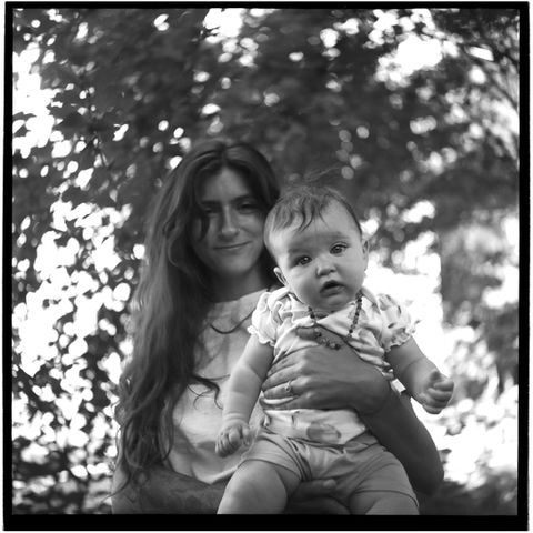Mother holds baby who is looking into camera