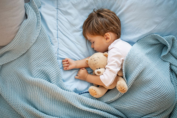 Photo of baby boy sleeping together with teddy bear. His favorite napping spot. Adorable k