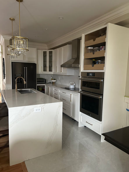 Modern kitchen renovation with white cabinets and marble countertops