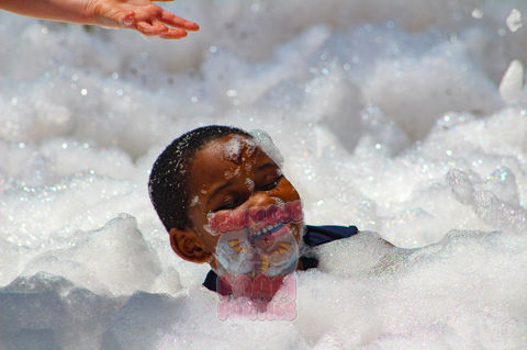 little boy playing in a sea of bubbly foam