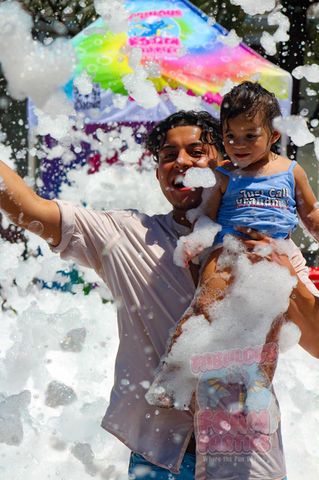 Dad holding child playing in foam party
