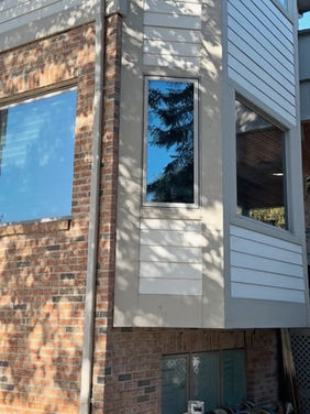 Residential ceramic window tint on a brick and siding home.