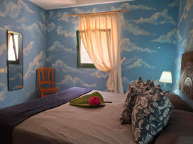 Schlafzimmer von Apartment C mit Bett und Fenstern.