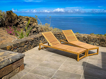 Sun loungers on the terrace with the ocean behind them