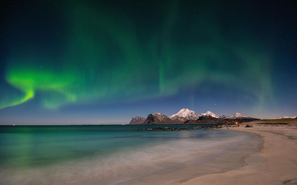 Polarlichter über weissem Strand auf den Lofoten mit Bergspitze im Hintergrund