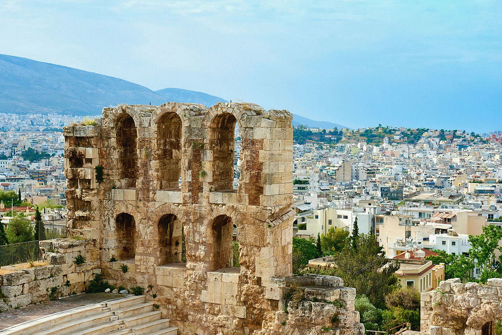 Ruine in Athen mit der Stadt im Hintergrund unter blauem Himmel