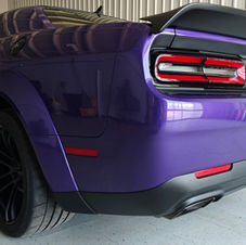Rear angle view of a purple 2023 Dodge Challenger Demon 170 inside a detailing shop, showcasing high-gloss finish after PPF, windshield protection, and ceramic coating.