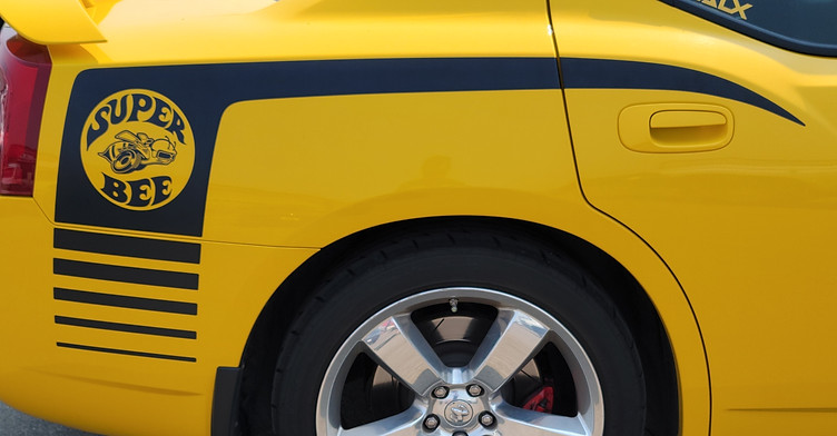 Yellow vinyl wrap on retro coupe with custom finish and chrome wheels
