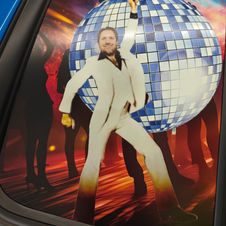 Custom vinyl decal of disco dancer with mirrored ball on rear vehicle window