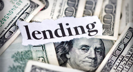 100 dollar bills sprawled out with the word lending over them