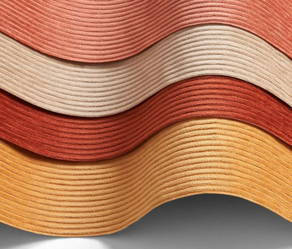 A creative wave of fabric layers in a gradient of reds and oranges, styled by Amanda Wolfson, showcasing her ability to create visual warmth in soft goods styling.