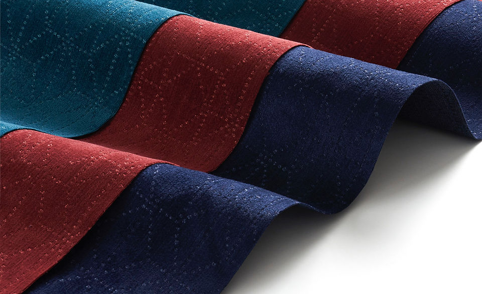 A meticulously styled collection of ties by Amanda Wolfson, a Chicago prop stylist, featuring deep navy, forest green, and tan colors with detailed patterns, showcasing the art of soft goods styling.