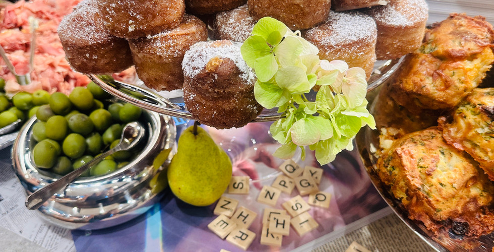 Assorted pastries, fruits, and desserts arranged artfully on tiered trays for a design event tablescape.