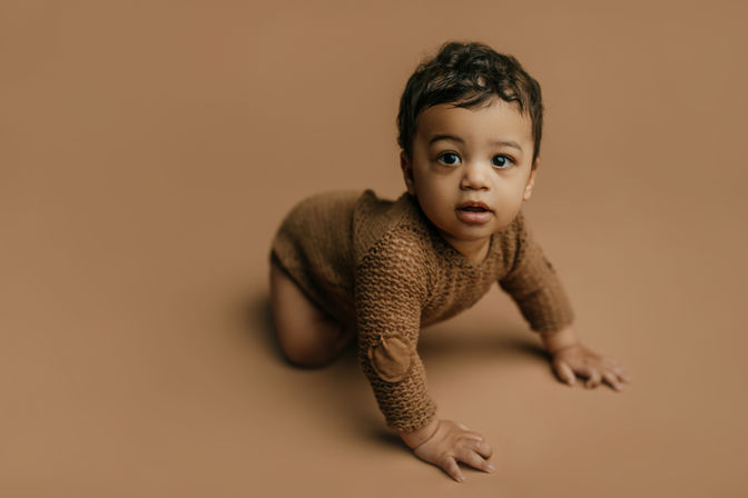 baby boy on tan seamless backdrop