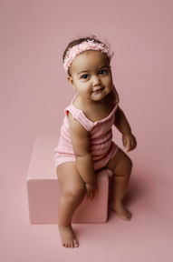 baby girl on pink box and backdrop