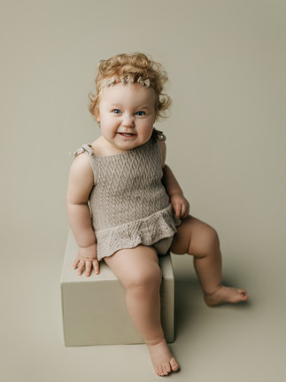 1 year old girl sitting on box