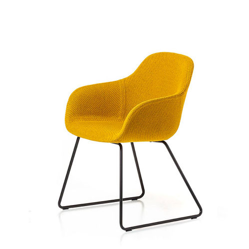 黃色扶手椅,外型圓潤,並有著獨特的金屬椅腳設計。