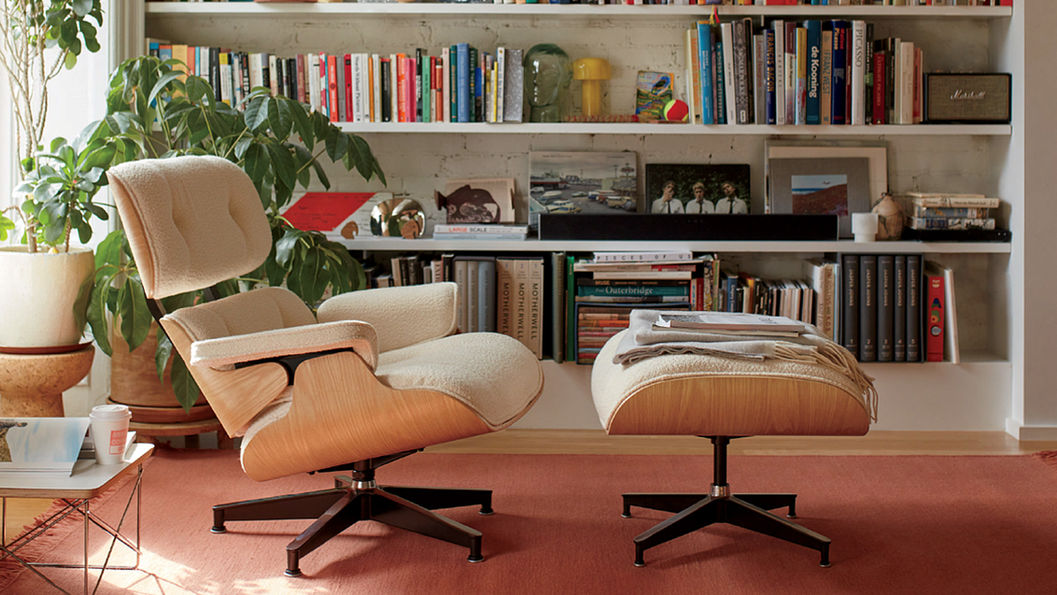 房間內擺放一組沙發椅搭配腳凳,後面有書櫃