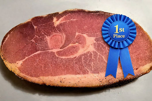 Ham curing was once a winter ritual in North Carolina, with families gathering to salt and hang meat. Pork remains a major agricultural product; North Carolina ranks among the top U.S. pork producers. Image credit - Copilot AI