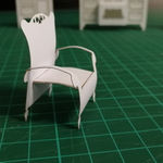 An intricate papercraft armchair model, highlighting the fine details in the "Grains of Recollection" immersive art project by Studio McGuire - Davy and Kristin McGuire