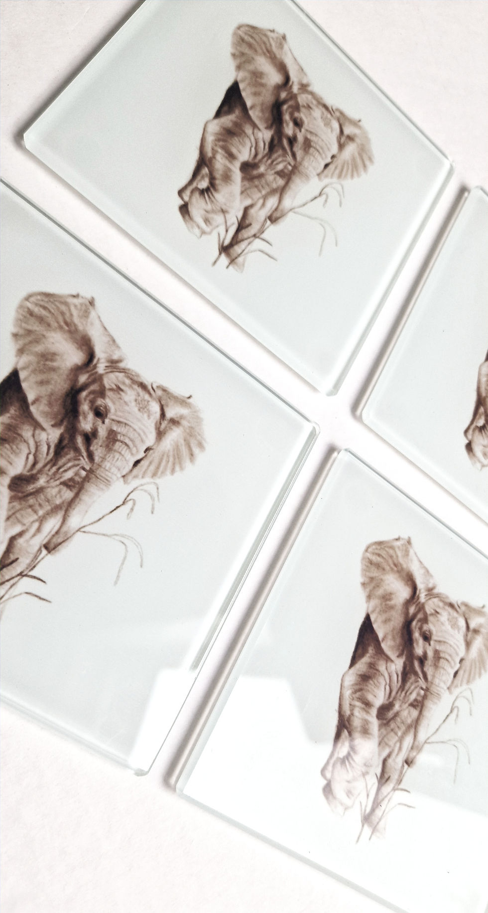 Thumbnail: Set of four square glass coasters with a baby elephant illustration by artist Emma Keys.