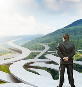 Businessman stands choosing his way.jpg