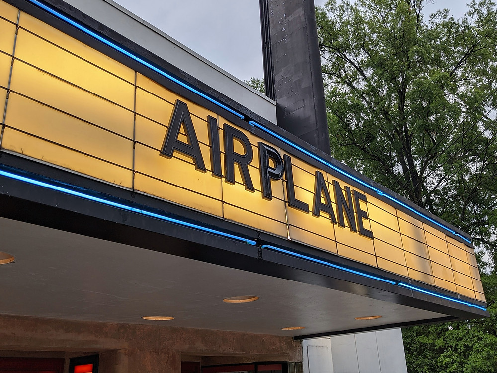 The billboard outside the theater, reading "Airplane"
