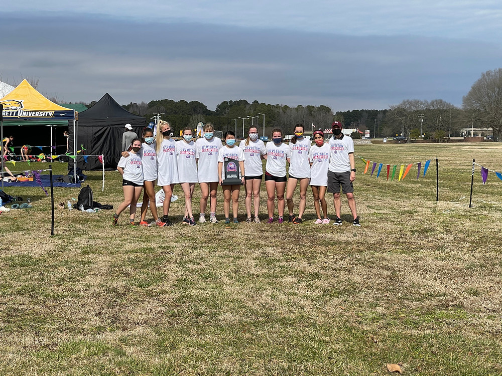 The cross country team standing together with masks on