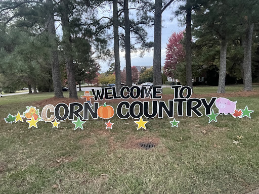 Signs on Meredith's front drive reading "Welcome to Corn Country"
