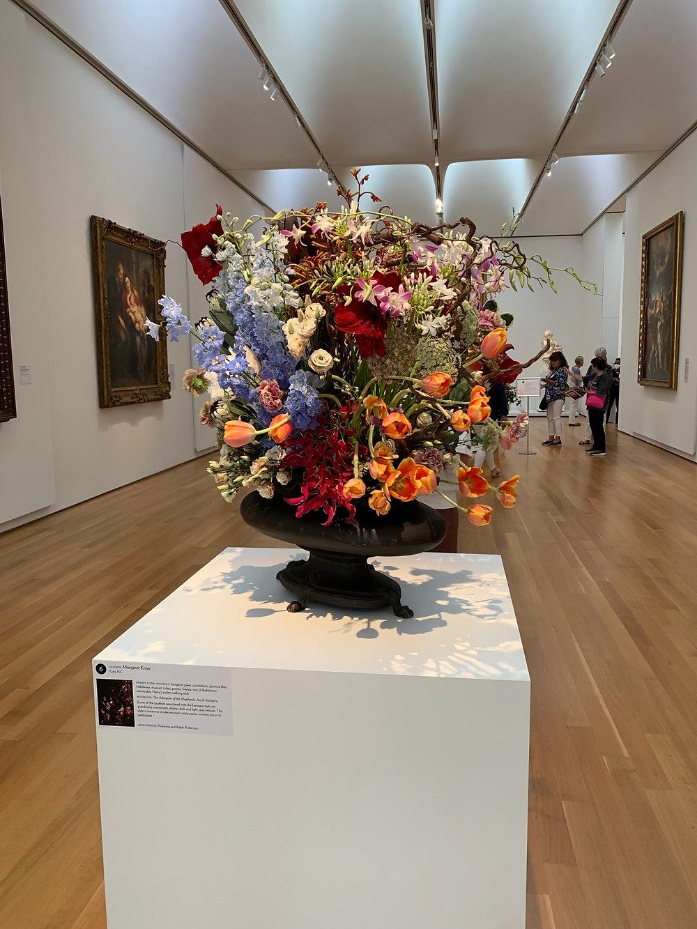 A vase with blue, orange, red, and pink flowers