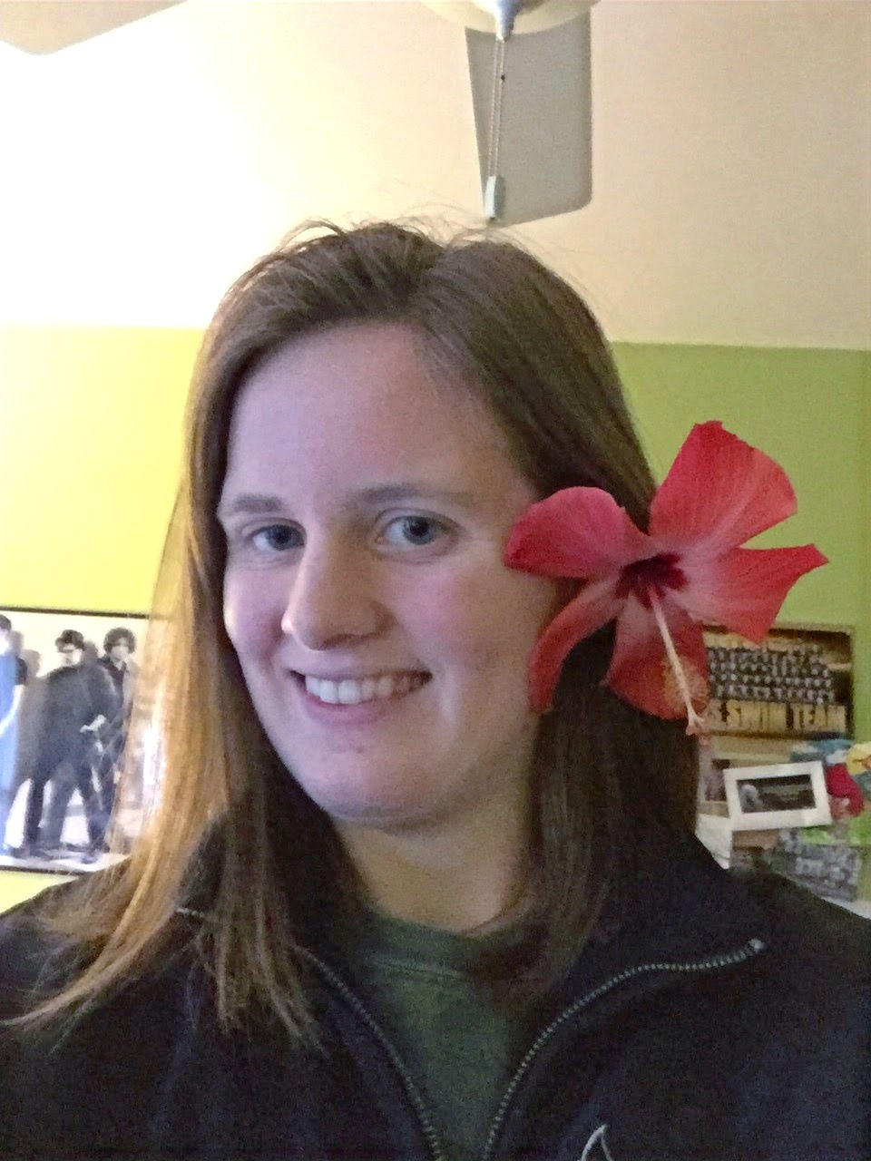 Erin smiling at the camera with a pink flower in her hair