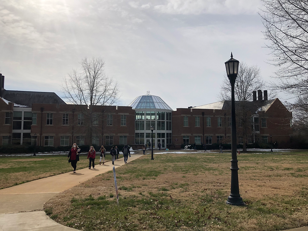 Masked students walk outside on Meredith's campus