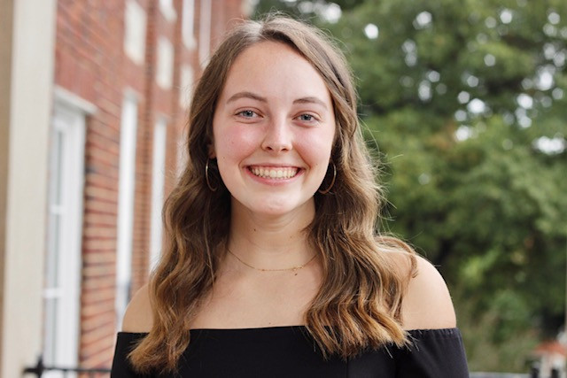 Anna standing on the balcony of Johnson Hall