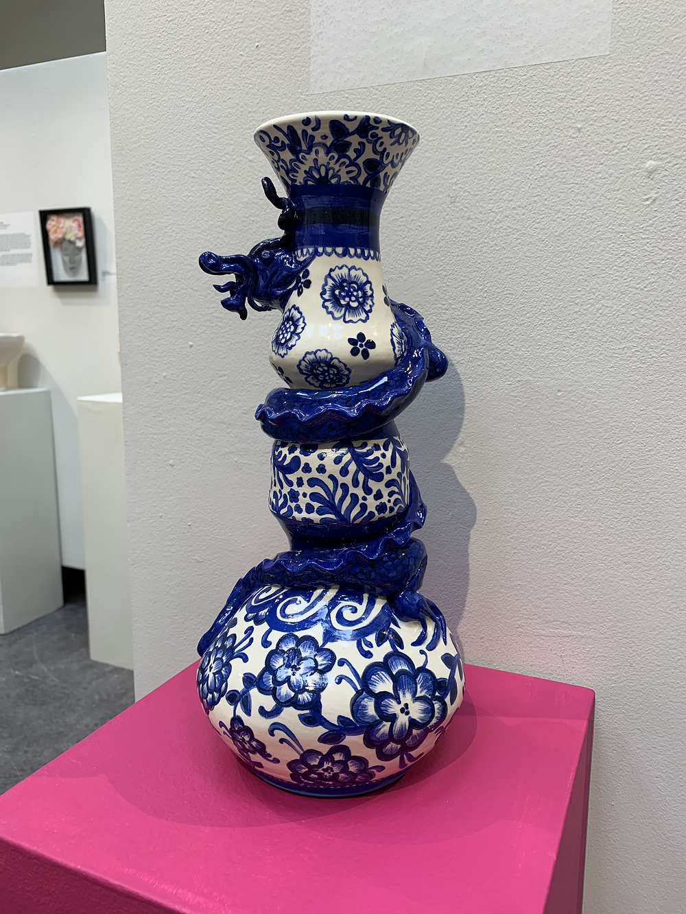 A blue and white ceramic vase with a dragon coiled around it
