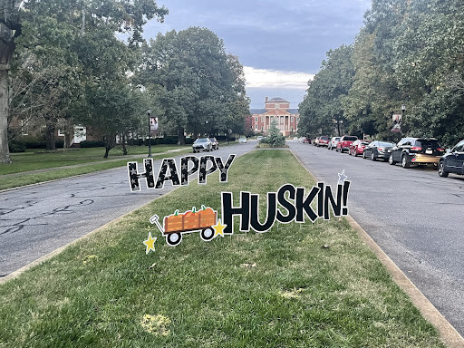 Signs on Meredith's front drive reading "Happy Huskin!"