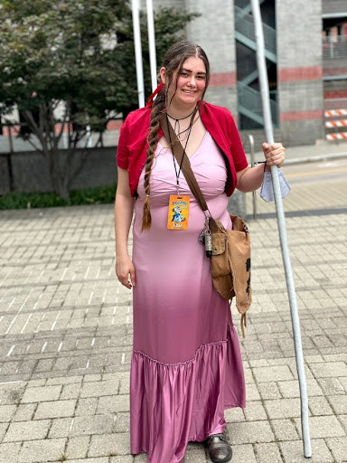Erin in a pink dress and red shawl with her hair in a braid