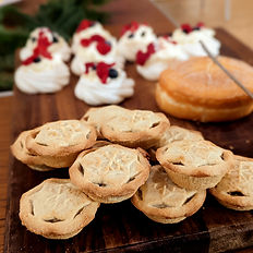 minced pies and sweet treats laid out on a wooden board
