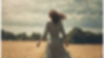 woman walking through a field in freedom.