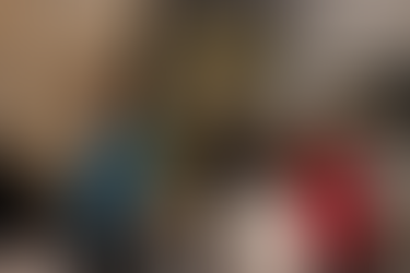 Group of colleagues standing and chatting in front of a training wall with climbing holds inside the gym.