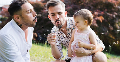 Famille soufflant des pissenlits
