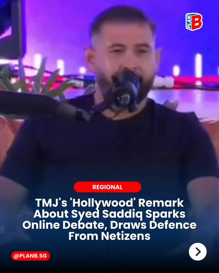 Bearded man speaks into a microphone on a purple-lit stage; overlay reads TMJ's Hollywood remark sparks online debate.