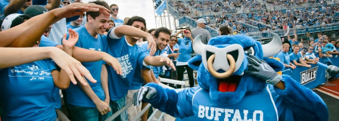 The UB Bills Mascot, a blue bull, interacting with crowds on the sideline at a game.
