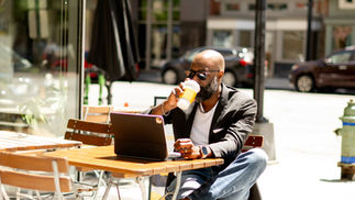 Ronald G. Victor, Founder of Limin' Professionals Luxury Travel Concierge, reviewing client communications while working outdoors